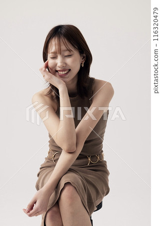 Korean Woman Poses in a Chair in Beige Knit Dress 116320479
