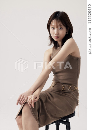Korean Woman Poses in a Chair in Beige Knit Dress 116320480
