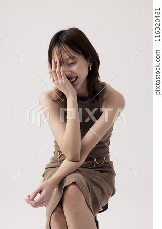 Korean Woman Poses in a Chair in Beige Knit Dress Korean Woman Poses in a Chair in Beige Knit Dress 116320481