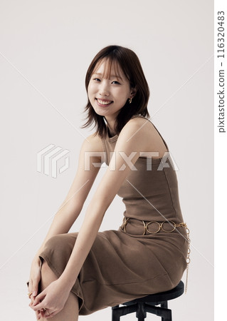 Korean Woman Poses in a Chair in Beige Knit Dress Korean Woman Poses in a Chair in Beige Knit Dress 116320483