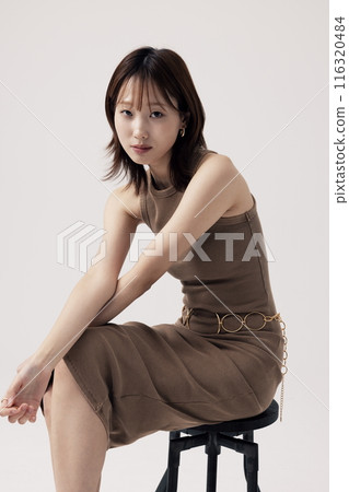 Korean Woman Poses in a Chair in Beige Knit Dress Korean Woman Poses in a Chair in Beige Knit Dress 116320484