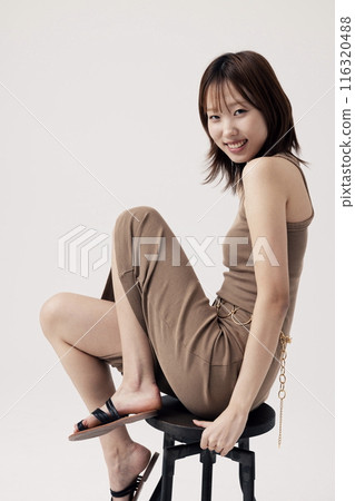 Korean Woman Poses Sitting on a Chair 116320488