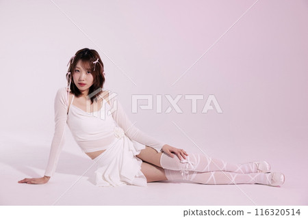 A Korean woman in her 20s who poses on the floor wearing a white ballet core look with a light pink background A Korean woman in her 20s who poses on the floor wearing a white ballet core look with a light pink background 116320514