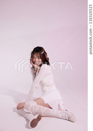 A Korean woman in her 20s wearing a ballet core look and sitting on the floor smiling with her chin on her chin 116320525