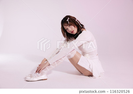 A Korean woman in her 20s who sits on the floor wearing a ballet core look and stares straight ahead 116320526