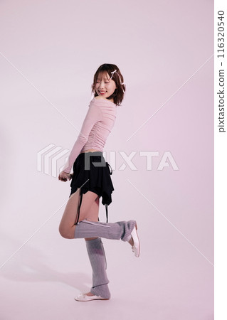 a Korean woman in her 20s posing while wearing a pink top and a black wrap skirt a Korean woman in her 20s posing while wearing a pink top and a black wrap skirt 116320540