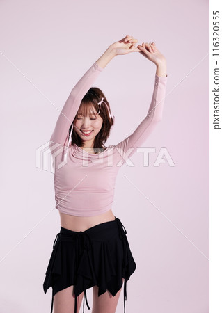 Korean woman in her 20s who wears a ballet core look style and extends her arms upward 116320555