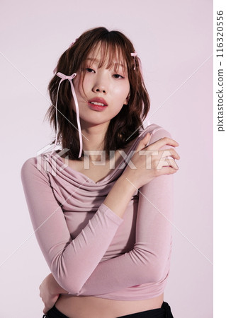 A Korean woman in her 20s wearing a pink top and a hair ribbon 116320556