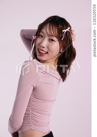A Korean woman in her 20s wearing a pink top and a hair ribbon A Korean woman in her 20s wearing a pink top and a hair ribbon 116320559