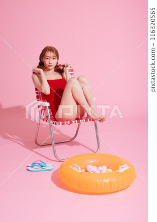A Korean woman in her 20s who sits on a chair wearing a monokini look and touches her pigtails A Korean woman in her 20s who sits on a chair wearing a monokini look and touches her pigtails 116320565