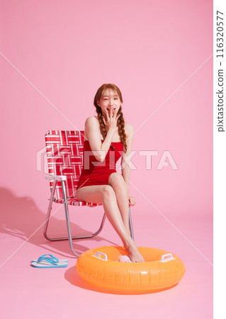 A Korean woman in her 20s wearing a monokini look and smiling while covering her lips with her hands A Korean woman in her 20s wearing a monokini look and smiling while covering her lips with her hands 116320577