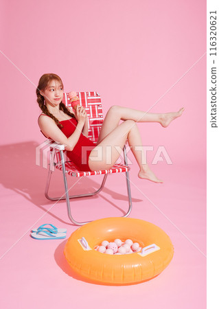 A Korean woman in her 20s sitting on a chair wearing a monokini look with a pink background 116320621