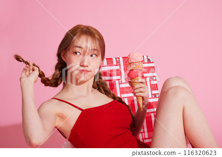 A Korean woman in her 20s who sits on a chair in a monokini look and holds ice cream 116320623