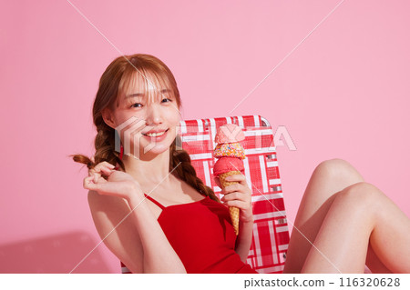A Korean woman in her 20s who sits on a chair in a monokini look and holds ice cream A Korean woman in her 20s who sits on a chair in a monokini look and holds ice cream 116320628