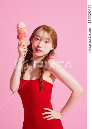 A Korean woman in her 20s wearing a monokini look with a pink background and holding an ice cream A Korean woman in her 20s wearing a monokini look with a pink background and holding an ice cream 116320681