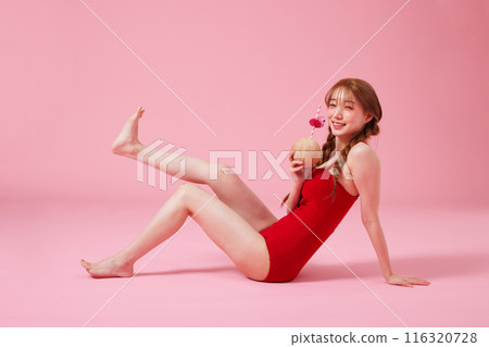 A 20s Korean Woman Sitting on the Floor in a Monokini Look and Holding a Coconut Drink A 20s Korean Woman Sitting on the Floor in a Monokini Look and Holding a Coconut Drink 116320728