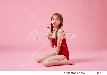 A 20s Korean Woman Sitting on the Floor in a Monokini Look and Holding a Coconut Drink A 20s Korean Woman Sitting on the Floor in a Monokini Look and Holding a Coconut Drink 116320730