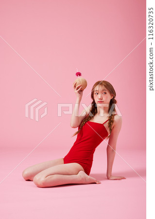 A 20s Korean Woman Sitting on the Floor in a Monokini Look and Holding a Coconut Drink A 20s Korean Woman Sitting on the Floor in a Monokini Look and Holding a Coconut Drink 116320735
