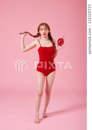 Korean woman in her 20s posing with a strawberry shaped drink in a monokini look 116320737