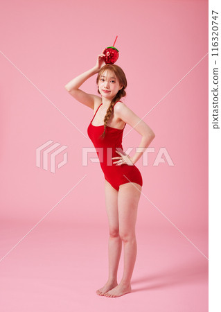 Korean woman in her 20s posing with a strawberry shaped drink in a monokini look 116320747