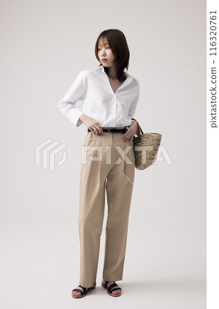 a Korean woman wearing a white shirt and beige pants with a bag 116320761