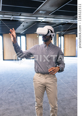 Using VR headset, man interacting with virtual environment in modern office 116322311