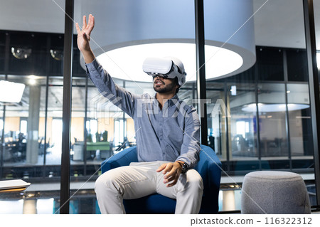 Using VR headset, man interacting with virtual environment in modern office Using VR headset, man interacting with virtual environment in modern office 116322312
