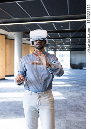 Using VR headset, businessman exploring virtual reality in modern office space 116322313