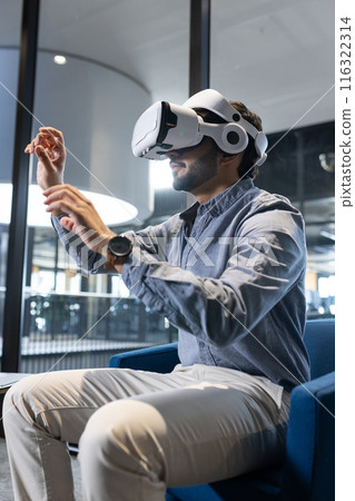 Using VR headset, man interacting with virtual environment in modern office Using VR headset, man interacting with virtual environment in modern office 116322314