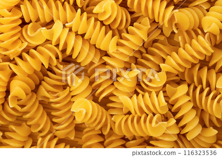 Close-up of raw, uncooked fusilli pasta. Pasta background texture Close-up of raw, uncooked fusilli pasta. Pasta background texture 116323536