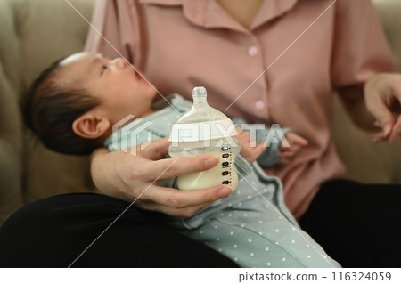 Close up mother holding a baby bottle of milk. Motherhood and childcare concept 116324059