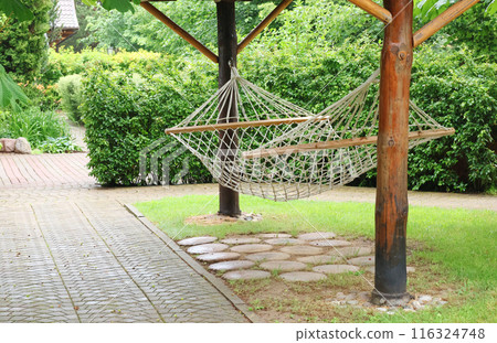 Rope hammock between trees in park. Holidays in nature. Rest and enjoyment.  116324748