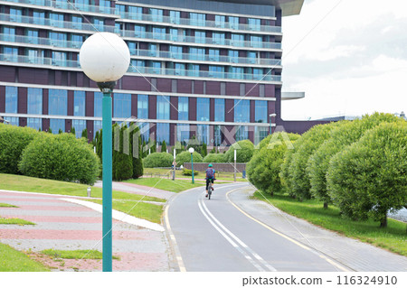 Ananonymous rides bicycle on path. Sports and recreation in city in summer. Nature and health. Ananonymous rides bicycle on path. Sports and recreation in city in summer. Nature and health. 116324910