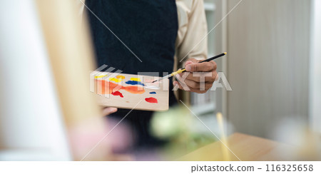 Artist Holding Paintbrush and Palette with Colorful Paints in Studio Setting, Creative Art Concept Artist Holding Paintbrush and Palette with Colorful Paints in Studio Setting, Creative Art Concept 116325658