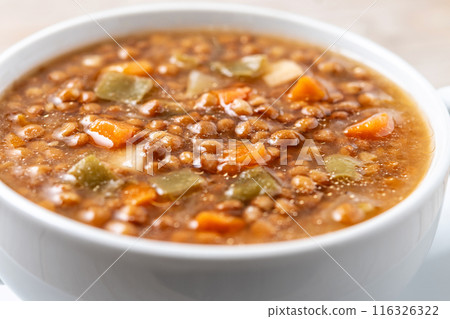 Lentil soup with vegetables in bowl on wooden table 116326322
