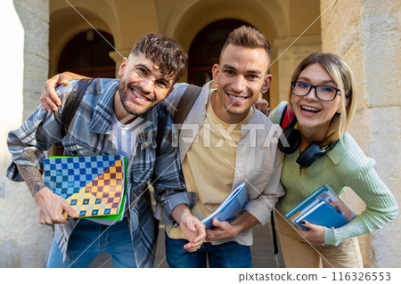 Joyful students with books standing in collage campus Joyful students with books standing in collage campus 116326553
