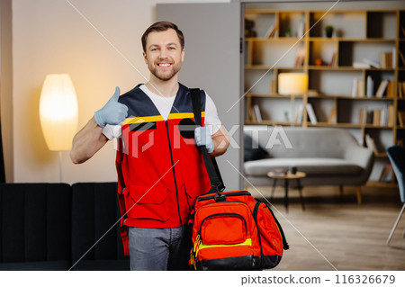 First aid course. A young male paramedic with a bag on his shoulders is standing in a classroom before a lecture 116326679