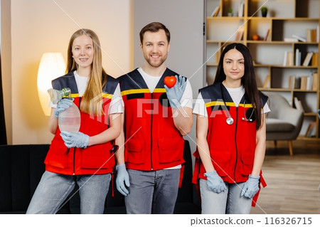 A group of young medical people in uniform stand in the middle of the classroom and smile after a first aid lesson. A man holds a red heart in his hands. Concept of assistance A group of young medical people in uniform stand in the middle of the classroom and smile after a first aid lesson. A man holds a red heart in his hands. Concept of assistance 116326715