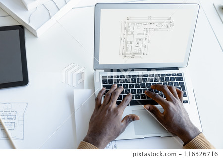 Man architect working with software on laptop using technical drafts drawings at office workplace Man architect working with software on laptop using technical drafts drawings at office workplace 116326716