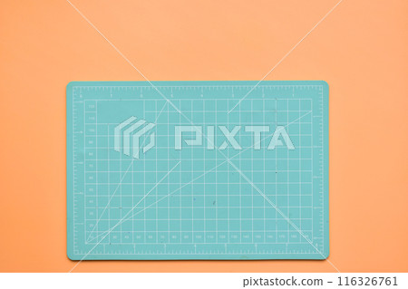 green cutting mat on orange background, object tool for design 116326761