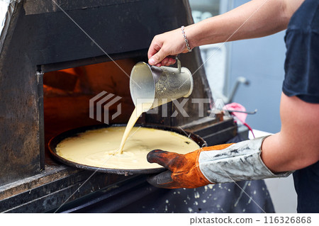 Socca being prepared in the oven in Nice, the French Riviera. Socca is a specialty of southeastern French cuisine. a pancake made from chickpea flour. 116326868