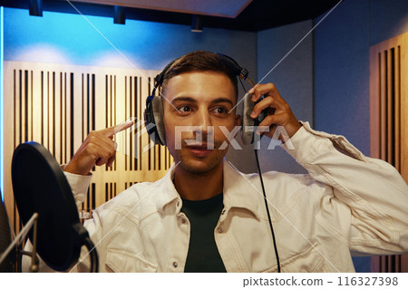 Young Man Recording Song In Studio Young Man Recording Song In Studio 116327398