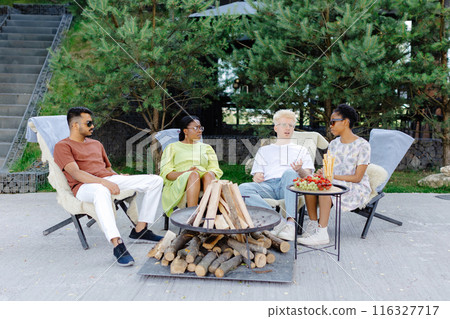 Friends celebrating outside, drinking wine and eating fruit on a picnic Friends celebrating outside, drinking wine and eating fruit on a picnic 116327717