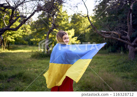 a woman in a red dress runs with the flag of Ukraine a woman in a red dress runs with the flag of Ukraine 116328712