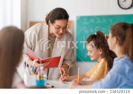 Happy kids and teacher at school 116329119