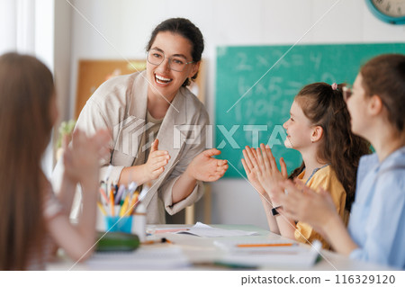 Happy kids and teacher at school Happy kids and teacher at school 116329120