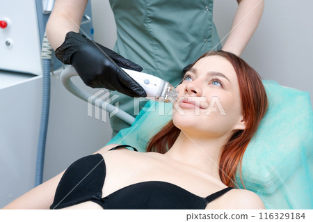 A woman is getting a facial treatment 116329184