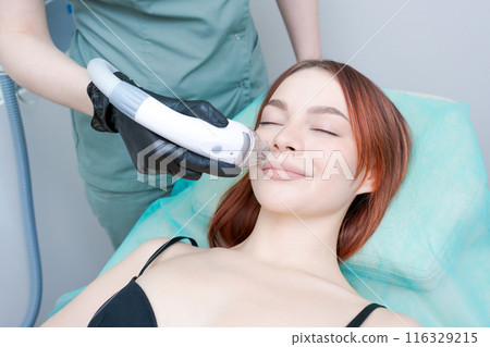 The woman is smiling and she is enjoying the treatment 116329215