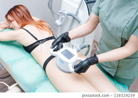 A woman is getting a body contouring treatment 116329239