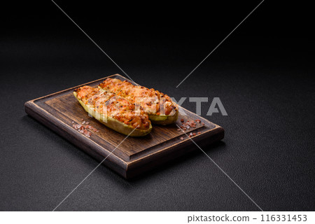 Zucchini halves baked with cheese, tomatoes, meat or meat substitute Zucchini halves baked with cheese, tomatoes, meat or meat substitute 116331453